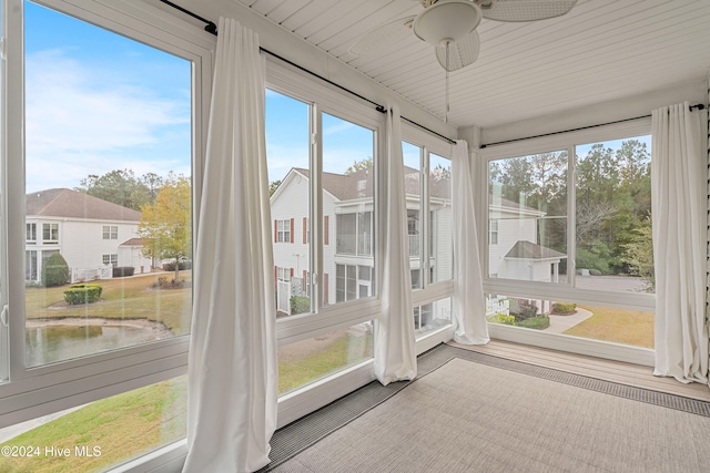 unfurnished sunroom featuring ceiling fan