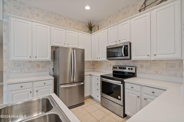 kitchen featuring white cabinets, light tile patterned floors, and appliances with stainless steel finishes