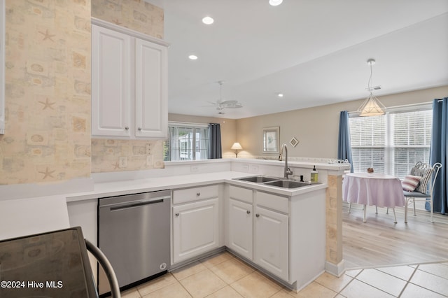 kitchen featuring dishwasher, stove, kitchen peninsula, sink, and white cabinetry