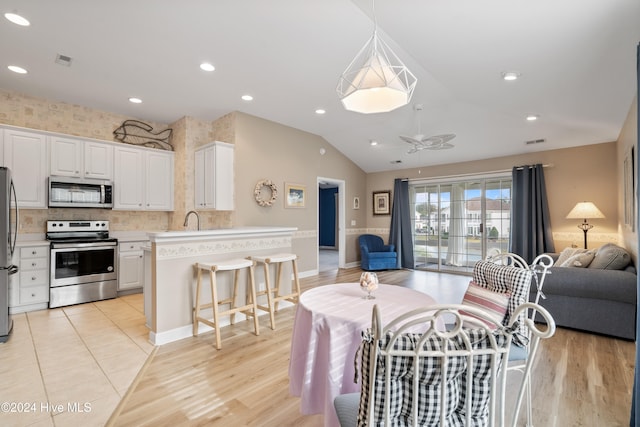 living room featuring ceiling fan, sink, light hardwood / wood-style floors, and lofted ceiling