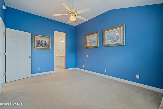 empty room featuring light carpet, vaulted ceiling, and ceiling fan