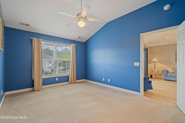 interior space featuring carpet flooring, vaulted ceiling, and ceiling fan