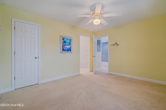 carpeted spare room with ceiling fan