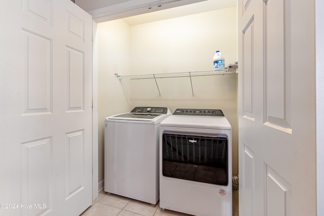 washroom with washing machine and dryer and light tile patterned flooring