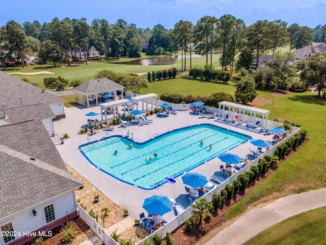 view of swimming pool featuring a lawn, a patio area, and a water view