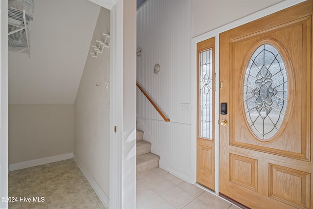 entrance foyer with light tile patterned floors and lofted ceiling