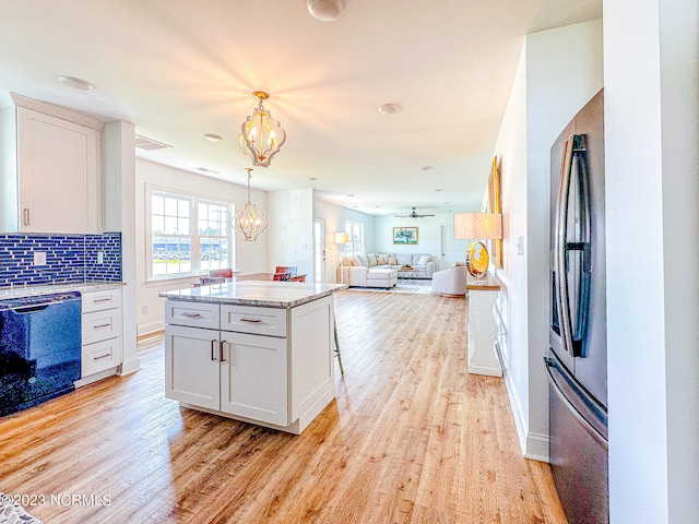 kitchen with white cabinetry, a center island, dishwasher, and light hardwood / wood-style flooring