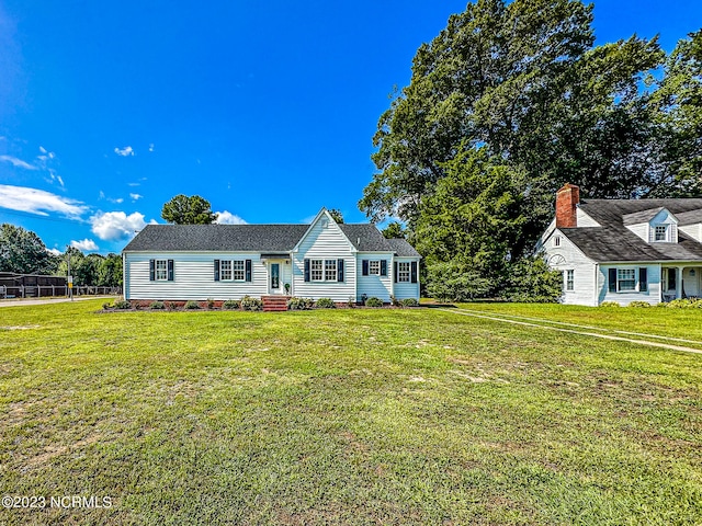 cape cod home with a front lawn