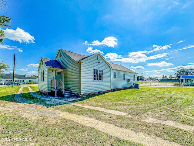 view of side of home with cooling unit and a yard