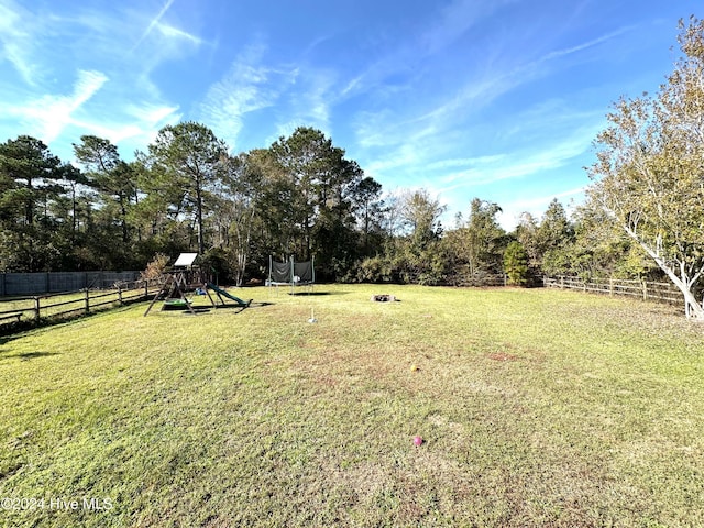 view of yard featuring a playground and a trampoline