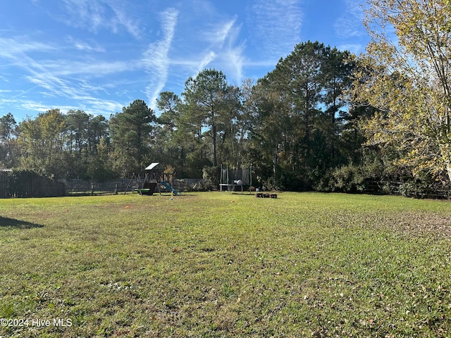 view of yard with a playground and a trampoline