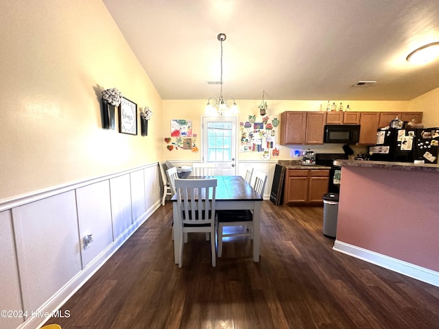 dining room with dark wood-type flooring, vaulted ceiling, and an inviting chandelier