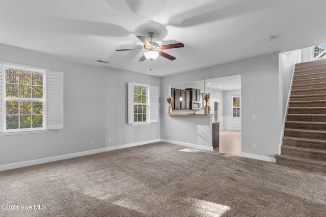 unfurnished living room featuring ceiling fan and carpet floors