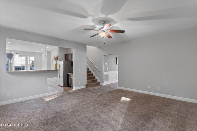 unfurnished living room with carpet and ceiling fan