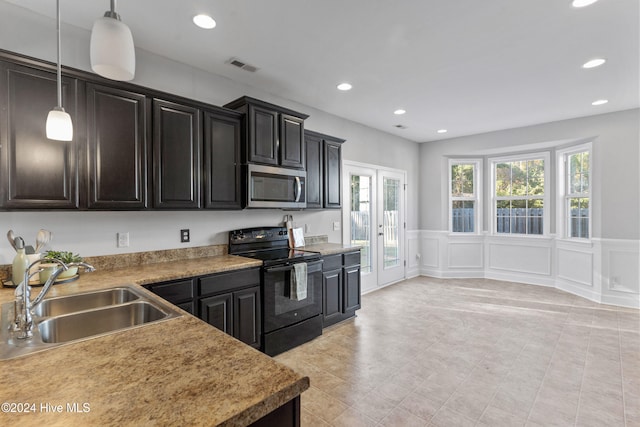 kitchen featuring pendant lighting, black range with electric stovetop, and sink