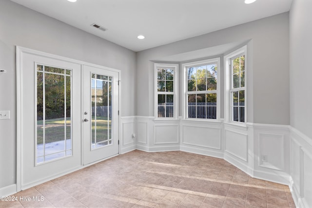 interior space featuring a healthy amount of sunlight, light tile patterned floors, and french doors