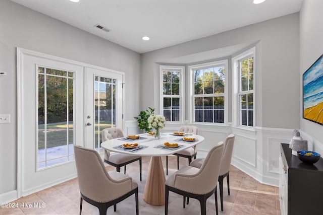 dining space with french doors, light tile patterned floors, and plenty of natural light