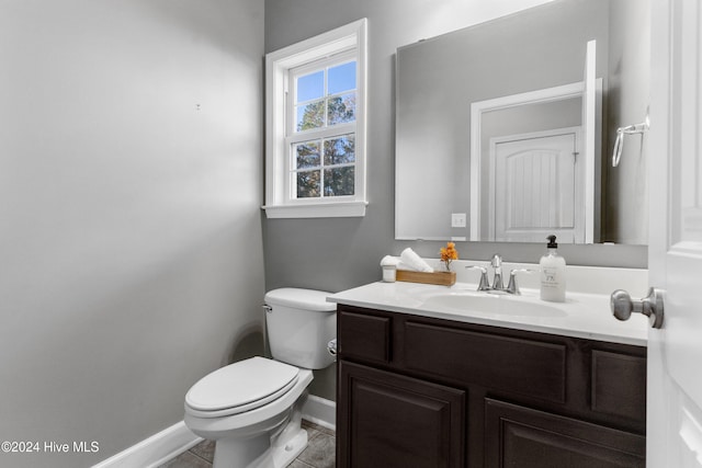 bathroom with tile patterned flooring, vanity, and toilet