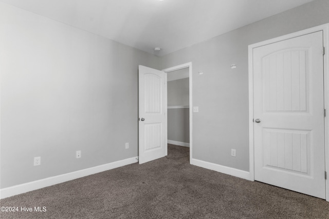 unfurnished bedroom with dark colored carpet