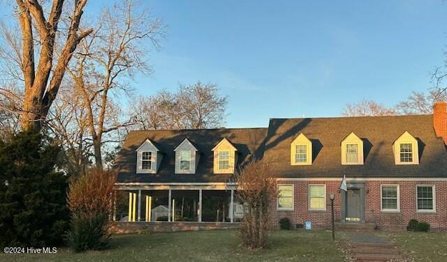 cape cod home with a sunroom and a front lawn