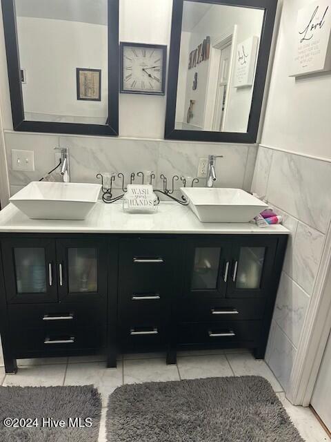 bathroom featuring vanity and tile walls