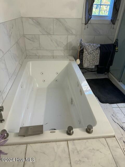 bathroom featuring a relaxing tiled tub