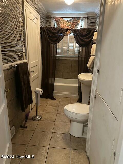 bathroom featuring tile patterned floors, shower / bath combo, and toilet