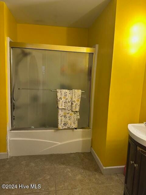 bathroom featuring tile patterned floors, vanity, and shower / bath combination with glass door