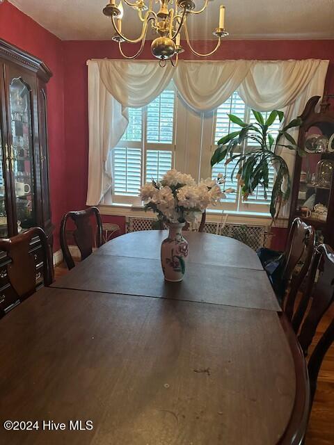 dining room with hardwood / wood-style flooring and a notable chandelier