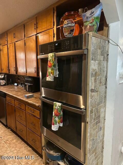 kitchen with light tile patterned floors and stainless steel appliances