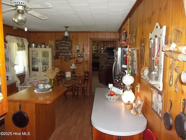 4271 Caratoke Hwy, Barco, NC 27917 - kitchen with wooden walls, wood finished floors, freestanding refrigerator, a ceiling fan, and brown cabinets
