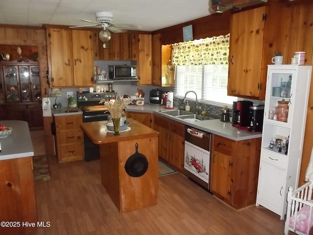 4271 Caratoke Hwy, Barco, NC 27917 - kitchen with stainless steel microwave, dishwasher, light wood-type flooring, a ceiling fan, and a center island