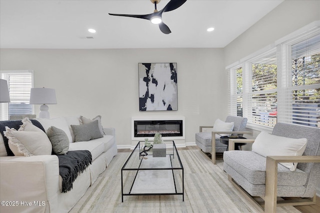 living room featuring ceiling fan and light hardwood / wood-style floors