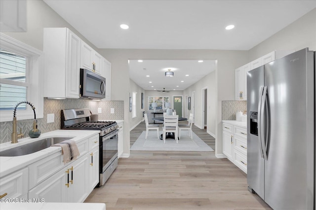 kitchen with white cabinetry, sink, ceiling fan, and appliances with stainless steel finishes