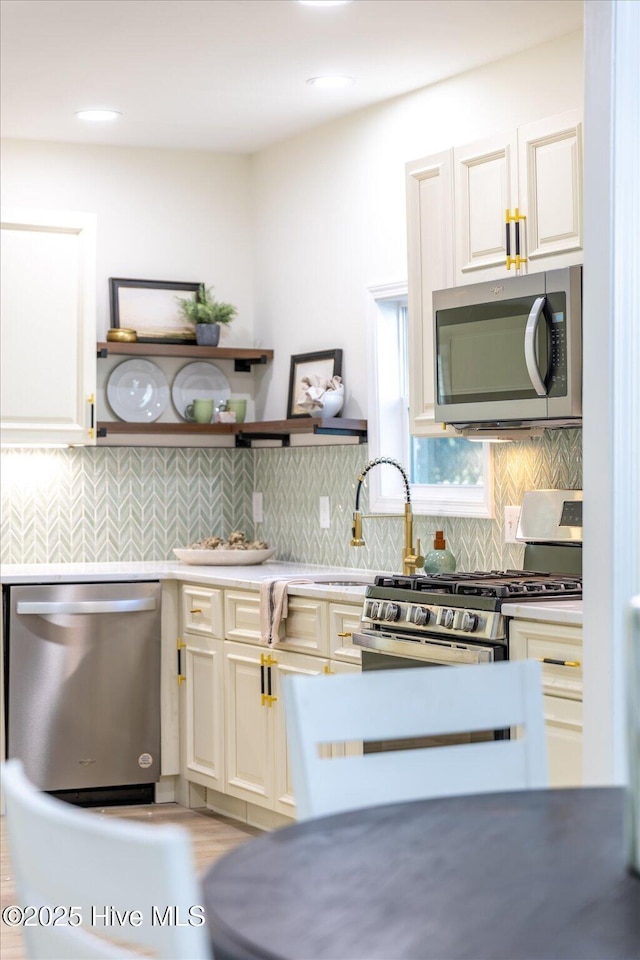 kitchen with decorative backsplash, sink, and appliances with stainless steel finishes