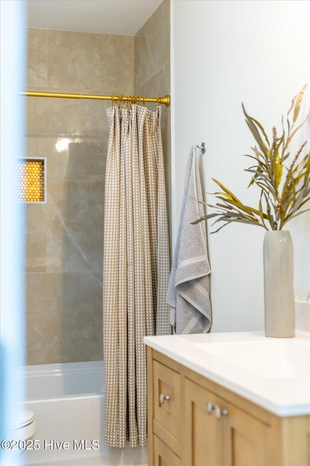 bathroom featuring vanity and shower / bathtub combination with curtain