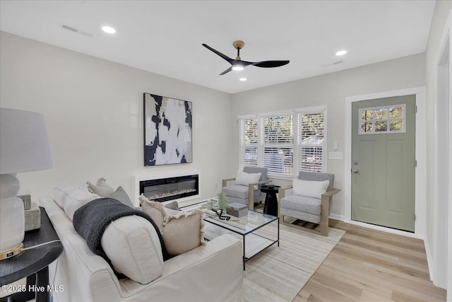 living room with ceiling fan and light hardwood / wood-style flooring