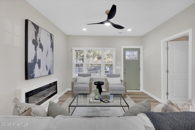 living room featuring ceiling fan and light hardwood / wood-style floors