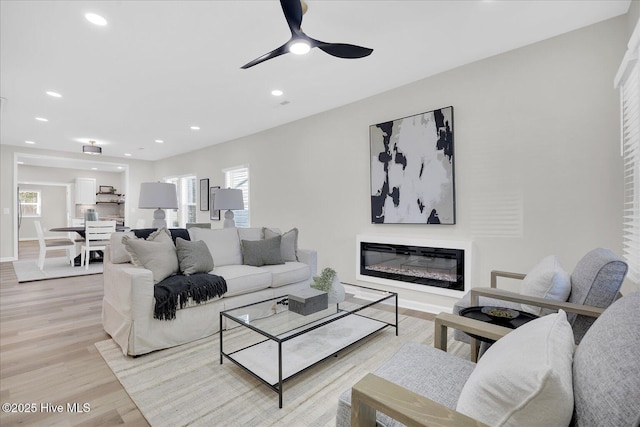 living room featuring ceiling fan and light hardwood / wood-style floors