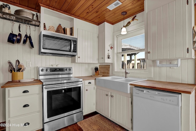 kitchen featuring butcher block counters, appliances with stainless steel finishes, decorative light fixtures, white cabinetry, and wood ceiling