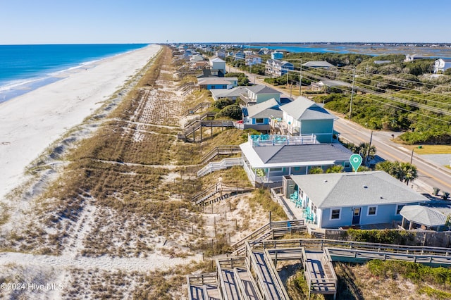 drone / aerial view with a water view and a beach view