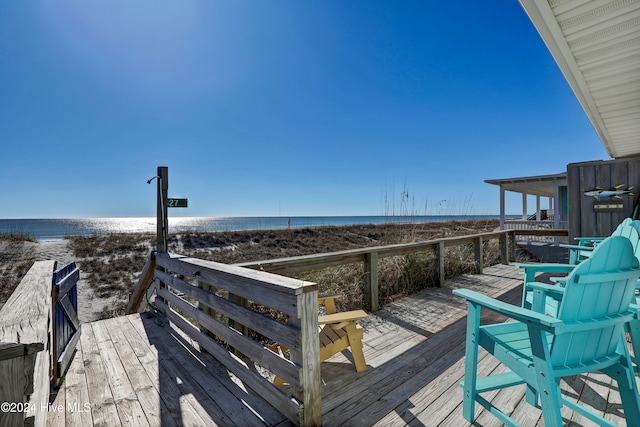 dock area featuring a deck with water view and a view of the beach