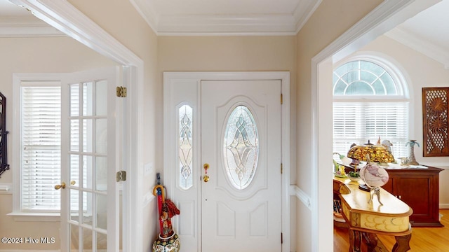 foyer entrance featuring plenty of natural light, light hardwood / wood-style flooring, and ornamental molding