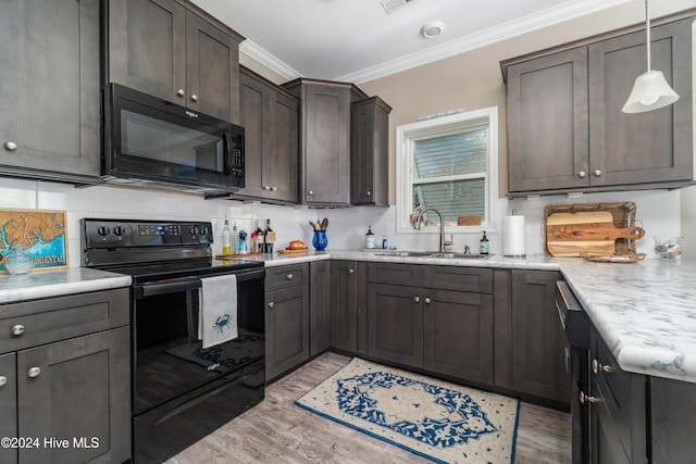 kitchen with crown molding, sink, black appliances, pendant lighting, and light hardwood / wood-style flooring