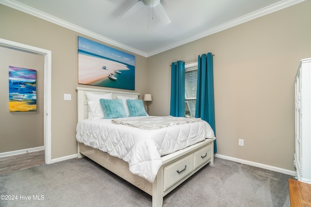 carpeted bedroom featuring ceiling fan and crown molding