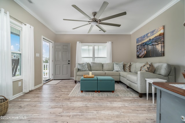 living room featuring a wealth of natural light, light hardwood / wood-style flooring, ceiling fan, and crown molding