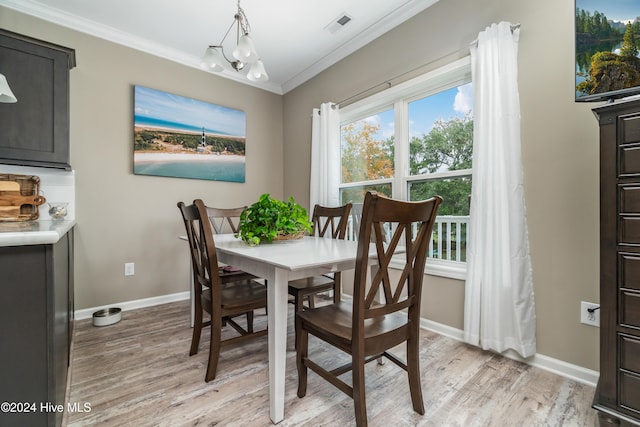 dining space with a chandelier, light hardwood / wood-style floors, and crown molding