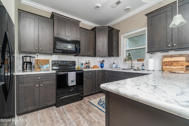 kitchen featuring black appliances, sink, hanging light fixtures, light wood-type flooring, and ornamental molding