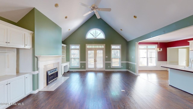 unfurnished living room with french doors, ceiling fan with notable chandelier, and dark hardwood / wood-style floors