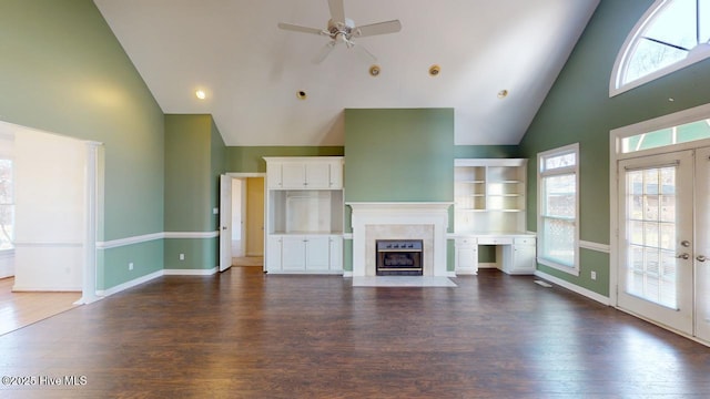 unfurnished living room with a premium fireplace, dark hardwood / wood-style flooring, high vaulted ceiling, and ceiling fan